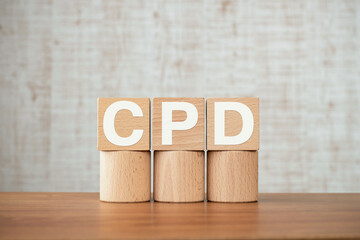 There is wood cube with the word CPD. It is an abbreviation for Continuing Professional Development...
