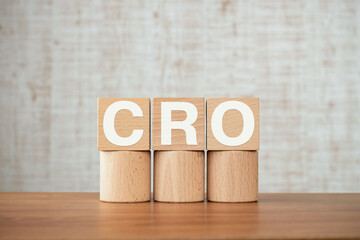 There is wood cube with the word CRO. It is an abbreviation for Contract Research Organization as eye-catching image.