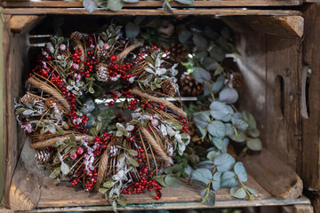 A Christmas wreath for sale at the market in a wooden box. The wreath is made of branches with...