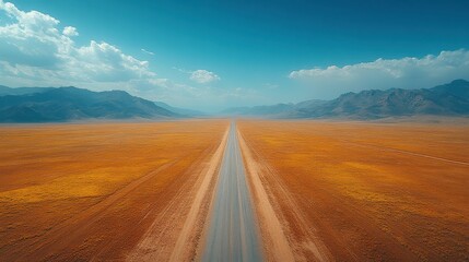 Fototapeta premium Vast Open Road Stretching Through Arid Desert Landscape Under Blue Sky with Dramatic Cloud Formation and Mountain Range in the Background