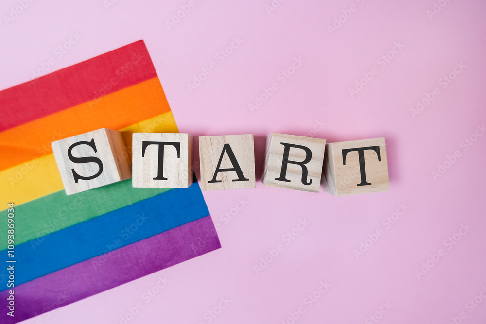 Poster rainbow flag and a set of wooden blocks with the word start written on them
