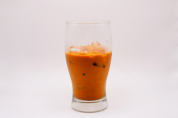 Iced caramel macchiato in a plastic cup, showing the beautiful swirls of coffee, milk, and caramel isolated