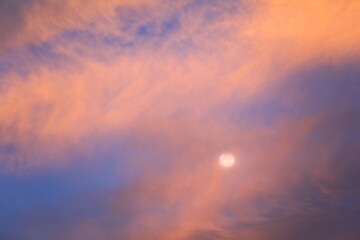 Obraz premium 西日に染まる雲と月