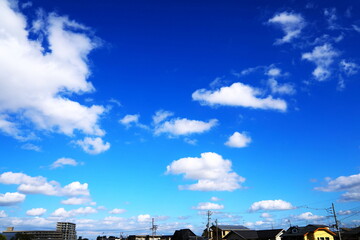 Fototapeta premium 青空に浮かぶ白い雲と住宅街