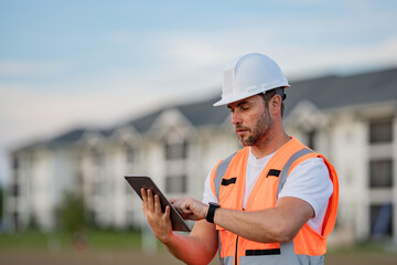 Engineer with tablet, building inspection. Serious engineer at new home. Construction manager in...