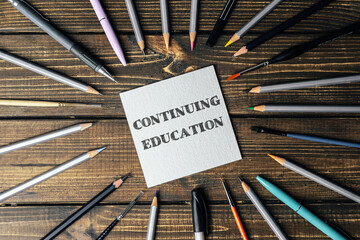Circle of pencils and pens with the word continuing education written in the center