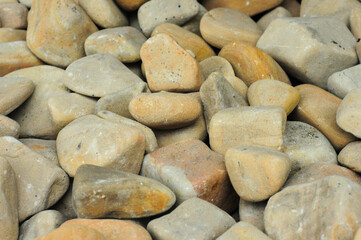 Close-up of smooth river stones in earthy tones for landscaping or decor use