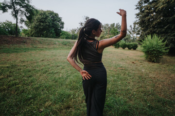 A young girl dances freely in a park, embodying joy and freedom. She moves gracefully amidst the...
