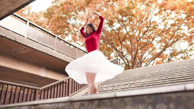 Ballet, dancer and Asian woman spin in city on stairs for street performance, dancing and practice in town. Creative, entertainment and ballerina in Japan for movement, balance and artistic talent