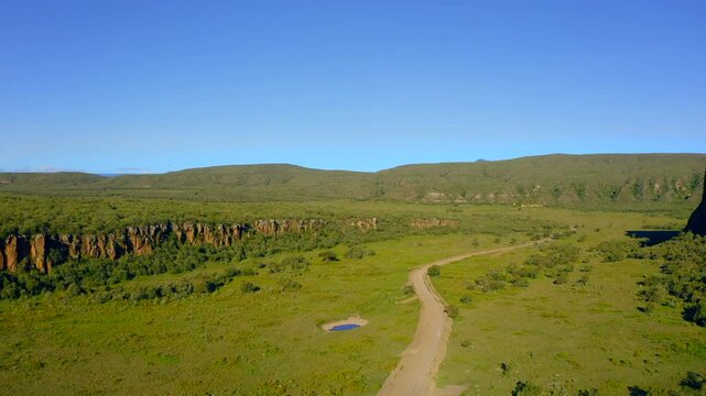 Hells Gate National Park is famous for its stunning scenery, vibrant greenery, and winding pathways through rocky cliffs, all under a beautiful blue sky, enhancing its natural allure. Kenya. Africa