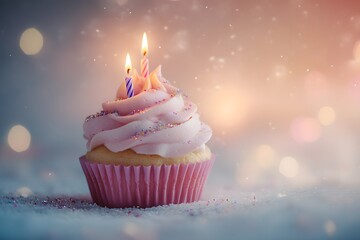 A delicious pink cupcake with lit candles, sprinkled with glitter, creates a festive mood against a dreamy, bokeh background.