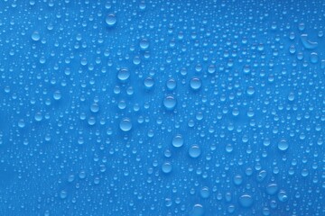 Water drops on blue background, top view