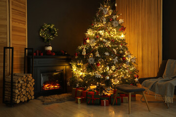 Christmas tree with festive decor, presents and fireplace in cozy room