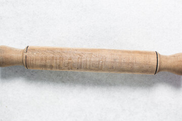 Top view of wood rolling pin on a white granite countertop, overhead view of a wooden rolling pin