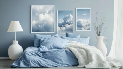 A tranquil sky-blue bedroom with soft blue bedding and a white throw blanket, accented by nature prints of clouds. A modern white lamp and a ceramic vase bring a light, airy feel to the room.