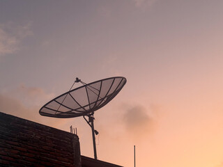 Satellite dish on the roof at sunset