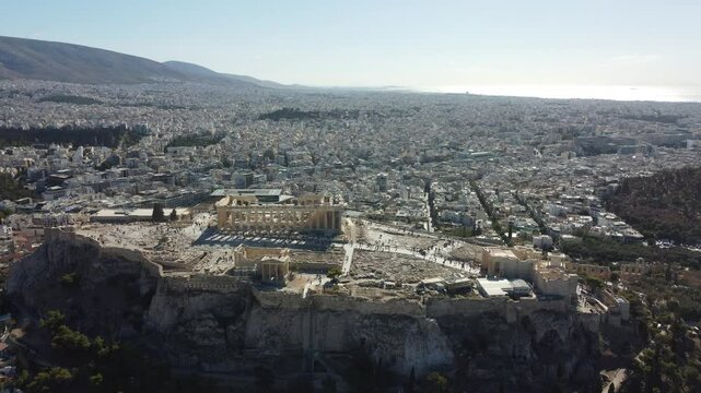 V&iacute;deo em 4K com vis&atilde;o a&eacute;rea do Partenon, em Atenas, Gr&eacute;cia. A imagem destaca o templo hist&oacute;rico, sua arquitetura cl&aacute;ssica e a paisagem urbana ao redor, com c&eacute;u claro e patrim&ocirc;nio grego