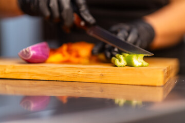 Chef chopping celery on wooden cutting board for fresh salad preparation