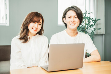 部屋にいる男女（ノートパソコン）
