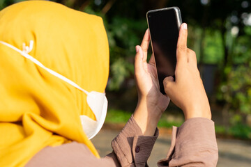 A person is deeply engrossed in their smartphone, their fingers scrolling through the screen. The...