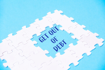Puzzle with the words get out of debt written in the middle