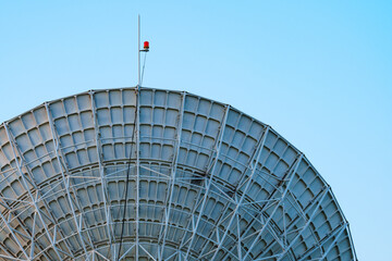 Naklejka premium Radio telescope giant paraboloid surface in morning sunlight with blue sky background