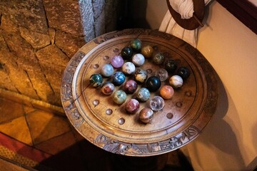 Ornate Wooden Game Board with Colorful Stone Marbles
