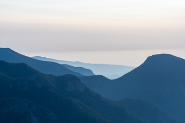 Serene mountain landscape at dusk with layers of blue hills fading into the horizon