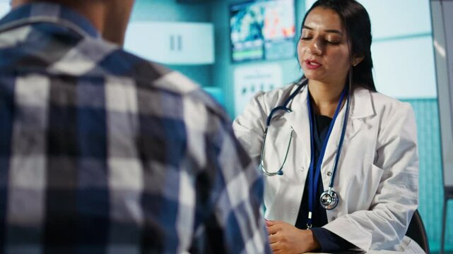 Optometry consultation in a medical office with an indian expert. Professional optometrist provides eye exam, using ophthalmoscope and optical tools to assess eyesight and discuss results. Camera B.
