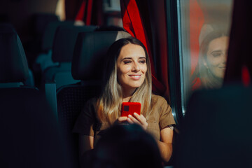 Woman Holding Smartphone Going on a Beautiful Train Journey. Passenger in a public transportation vehicle checking her mobile 
