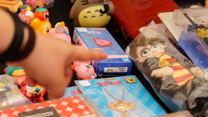 Naklejka premium Budokan Geek Convention In GUAYAQUIL, ECUADOR - OCT 13, 2024 - Close-up of a variety of collectible toys and merchandise, featuring Harry Potter, Kirby, and Totoro items, perfect for fans and pop cult