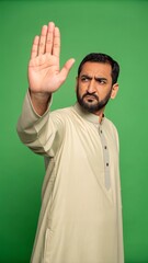 Naklejka premium Serious man making stop gesture against green background