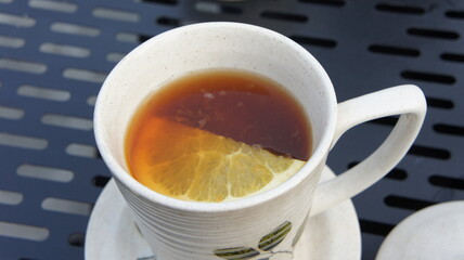 Warm Cup of Tea with Lemon Slice on Outdoor Table