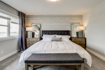 A large bed with a gray and white bedspread and pillows