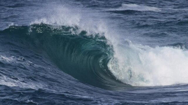 Powerful wave barrels forward, foam ball spitting out as it curls in slow motion