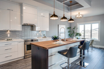 A modern kitchen with a wooden island and a large window