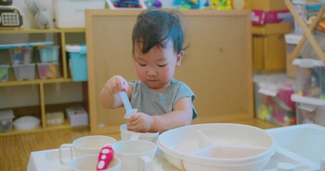 young child holding a syringe while engaging in imaginative play doing chemistry experiments science, explores and learns through play with educational toys environment. - Powered by Adobe