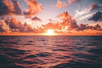 Obraz premium Breathtaking Sunset Over Calm Ocean Water with Colorful Clouds Illuminating the Sky in Vivid Shades of Orange, Pink, and Blue, Creating a Peaceful Atmosphere