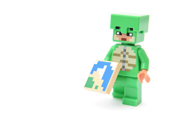 Naklejka premium Lego minifigure of popular game Minecraft with pixel map isolated on white. Editorial illustrative image of popular plastic toys.