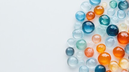 A variety of colorful glass marbles is arranged on a smooth white background, showcasing their shine and unique designs