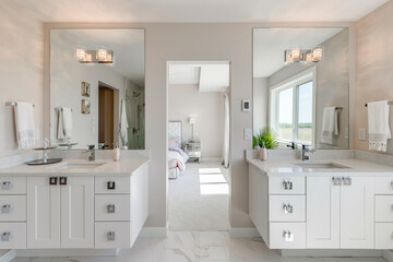 The bathroom is a large, white space with two sinks and two mirrors