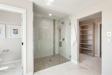 A bathroom with a shower and a walk in closet
