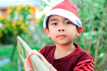 A boy wearing a red hat celebrates Christmas.	