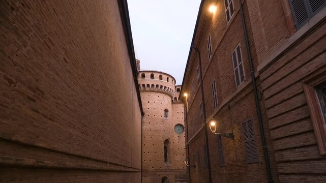 Tilt down establishing dolly along wide empty street on outside edge of wall, stone streets in Loretto Italy