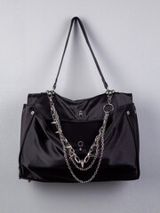 Close up of black trendy bag with silver chain  on white background