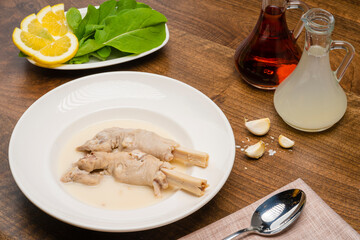 Lamb soup specific to Turkish culture. Soup in a white bowl decorated with spices on a dark colored table.