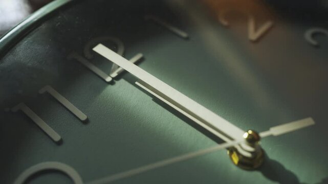 Close-up shot of hands of a wall clock at noon on 12 o' clock