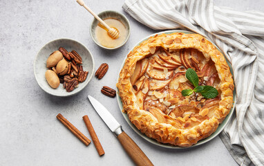 Delicious homemade apple galette decorated with almond flakes and fresh mint