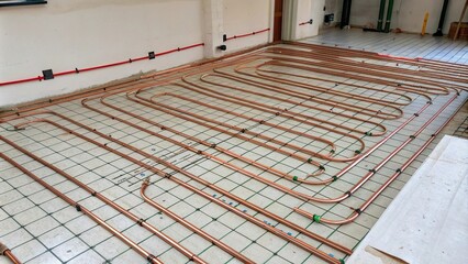 Underfloor heating system with copper pipe installation, underfloor heating, plumbing work, modern architecture