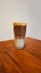 glass of coffee layered with milk on the table